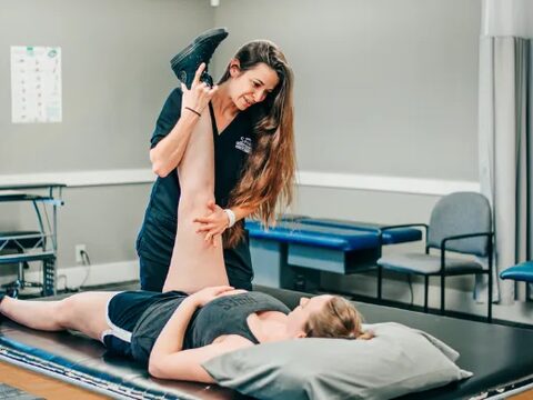 Physical therapist stretching a patient's leg at Riverside