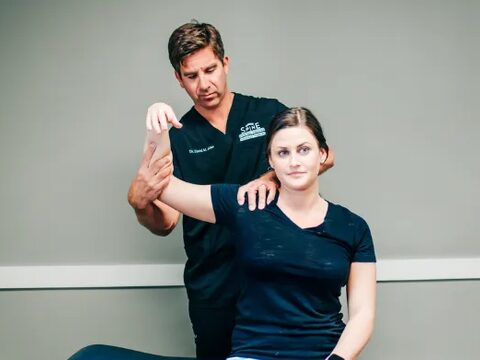 Two Riverside providers working with a patient in the rehab gym